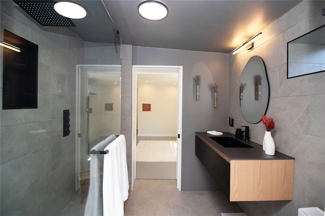 hallway featuring tile walls and a sink