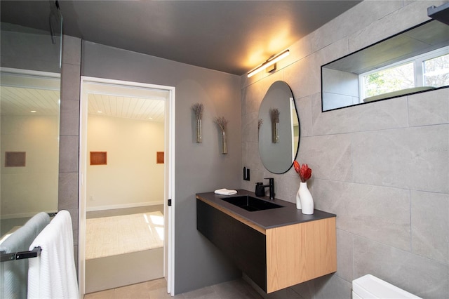 bathroom with vanity and tile walls