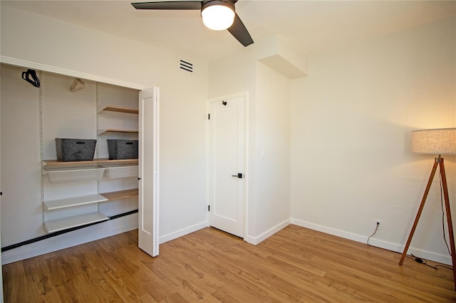 unfurnished bedroom with baseboards, visible vents, ceiling fan, wood finished floors, and a closet