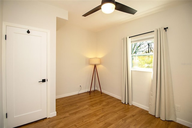 spare room with a ceiling fan, baseboards, and wood finished floors