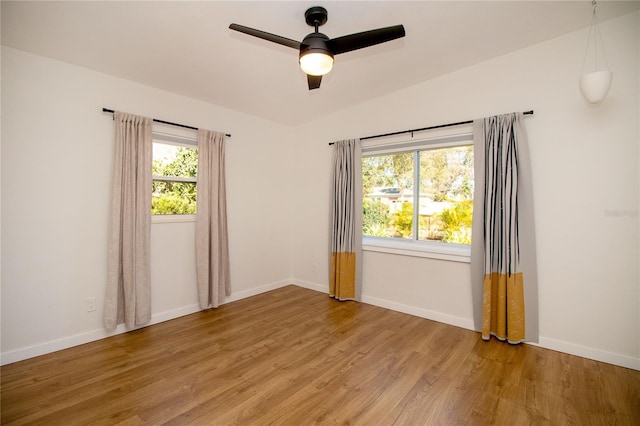 unfurnished room featuring a ceiling fan, baseboards, vaulted ceiling, and light wood finished floors