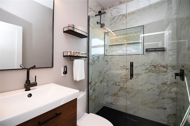 full bath with toilet, a marble finish shower, and vanity