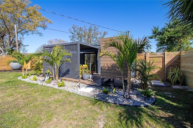 back of house featuring a lawn and a fenced backyard