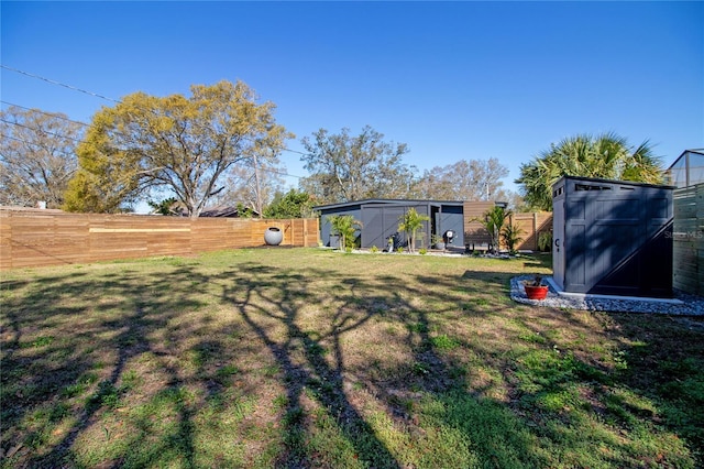 view of yard with a fenced backyard and an outbuilding