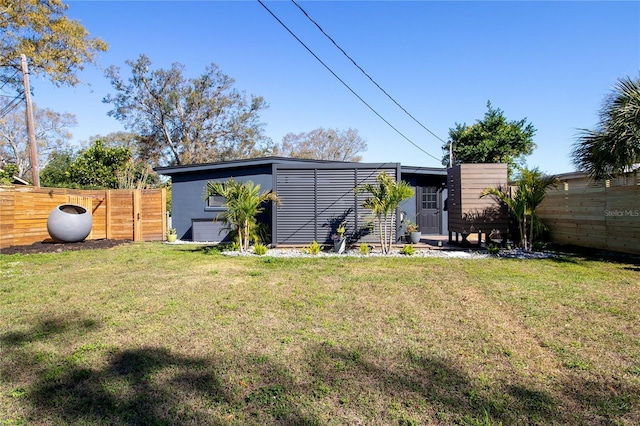 back of house featuring a yard and fence