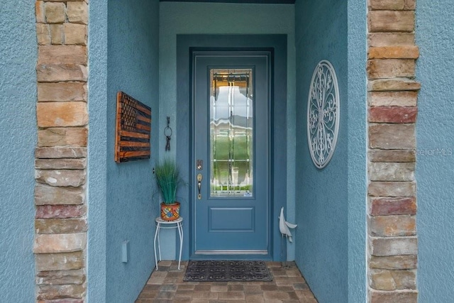 view of exterior entry with stucco siding