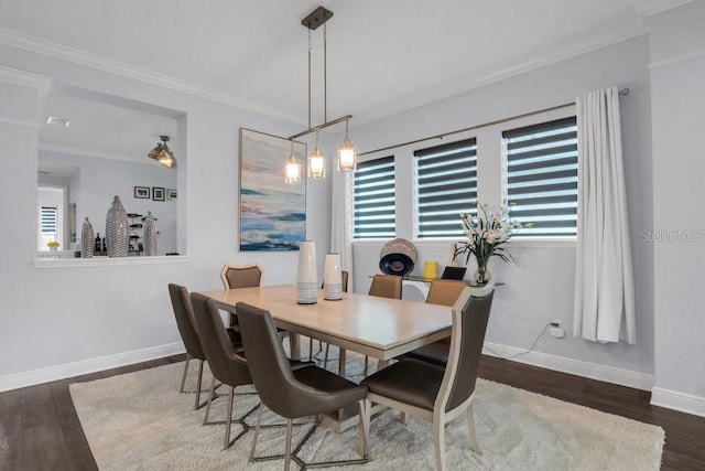 dining area featuring baseboards, wood finished floors, visible vents, and crown molding