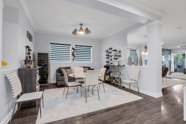 dining area with ornate columns, visible vents, ornamental molding, wood finished floors, and baseboards