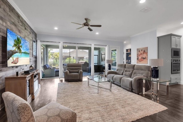 living area featuring dark wood finished floors, recessed lighting, visible vents, ornamental molding, and a ceiling fan