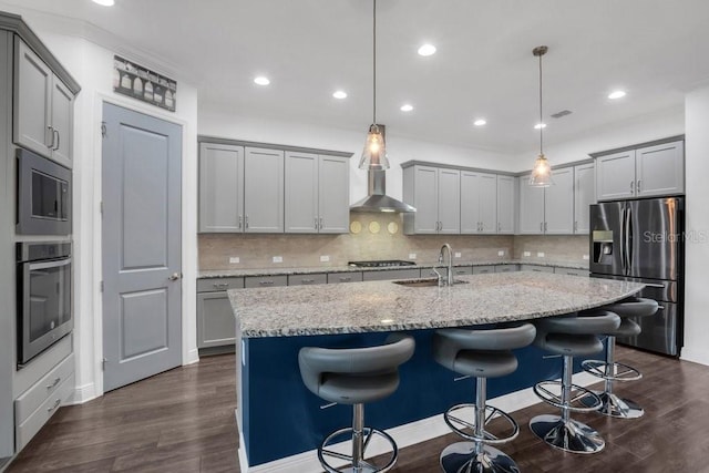 kitchen featuring stainless steel appliances, a sink, gray cabinetry, and dark wood-style floors