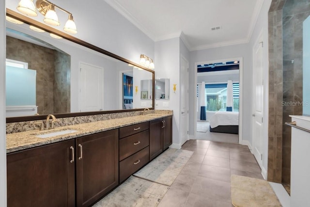 ensuite bathroom featuring double vanity, ornamental molding, and a sink