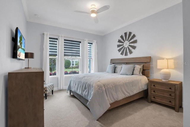 bedroom featuring a ceiling fan, crown molding, and light colored carpet