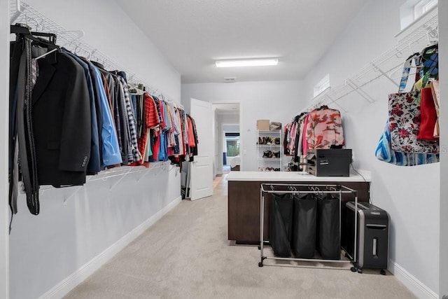 walk in closet featuring light colored carpet