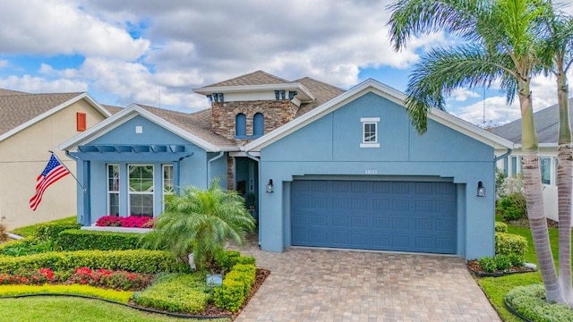 mediterranean / spanish house featuring a garage, a shingled roof, decorative driveway, and stucco siding