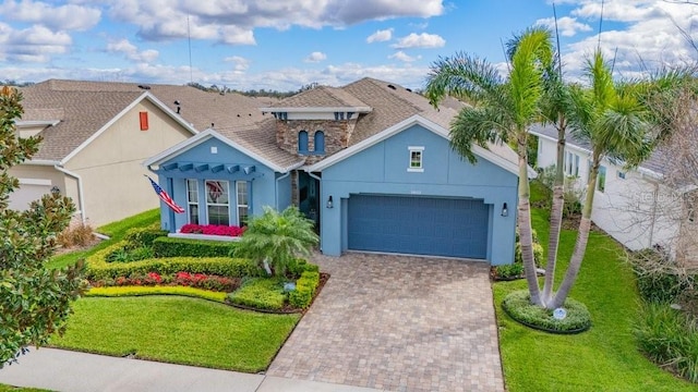 view of front of house featuring a garage, a front lawn, decorative driveway, and stucco siding