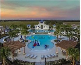 pool at dusk with a community pool