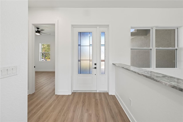 foyer entrance featuring light wood-style flooring and baseboards