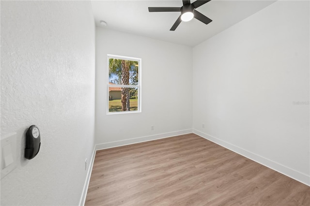 unfurnished room with light wood-type flooring, baseboards, and a ceiling fan