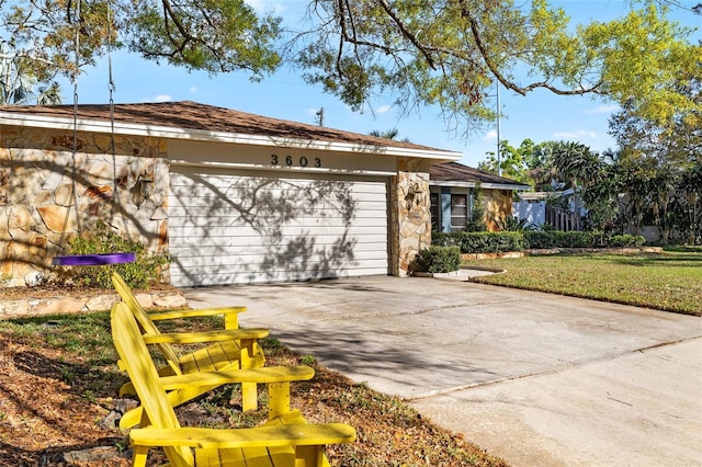 ranch-style house featuring an attached garage, stone siding, and concrete driveway