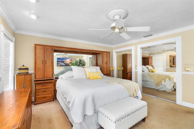 bedroom with crown molding, multiple closets, light colored carpet, visible vents, and ceiling fan