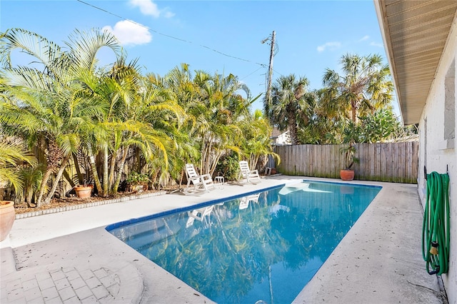 view of swimming pool featuring a fenced backyard, a fenced in pool, and a patio