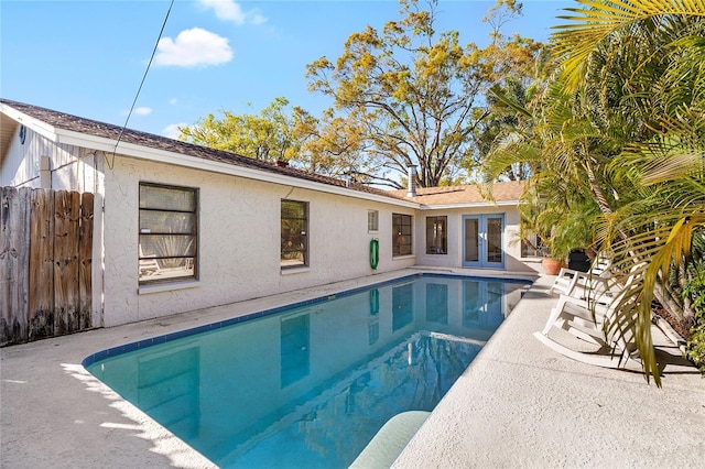 outdoor pool featuring a patio, french doors, and fence