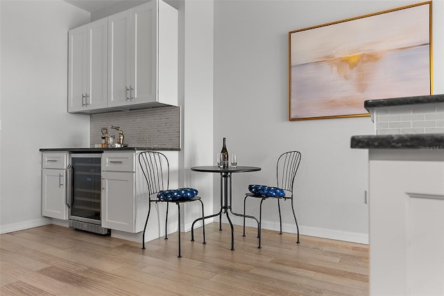 226 5th Ave N Unit 901, Saint Petersburg, FL 33701 - bar with light wood-type flooring, beverage cooler, backsplash, and a bar