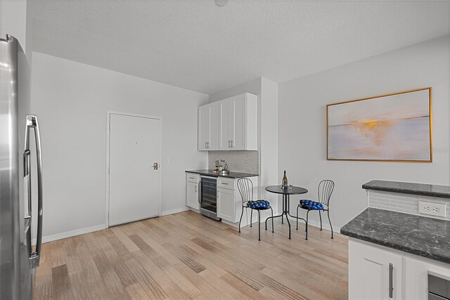 226 5th Ave N Unit 901, Saint Petersburg, FL 33701 - kitchen featuring freestanding refrigerator, white cabinets, light wood-style flooring, and wine cooler