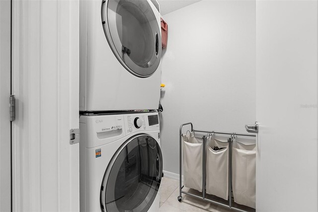226 5th Ave N Unit 901, Saint Petersburg, FL 33701 - washroom with light tile patterned floors, stacked washer and dryer, and baseboards