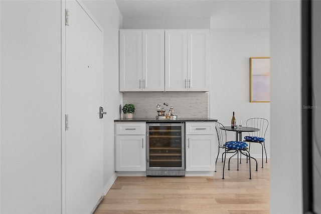 226 5th Ave N Unit 901, Saint Petersburg, FL 33701 - bar with light wood-style flooring, beverage cooler, a dry bar, baseboards, and tasteful backsplash