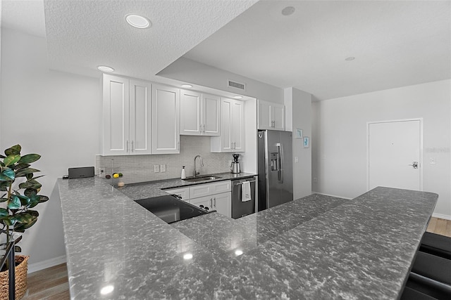 226 5th Ave N Unit 901, Saint Petersburg, FL 33701 - kitchen featuring stainless steel appliances, wood finished floors, a sink, visible vents, and tasteful backsplash