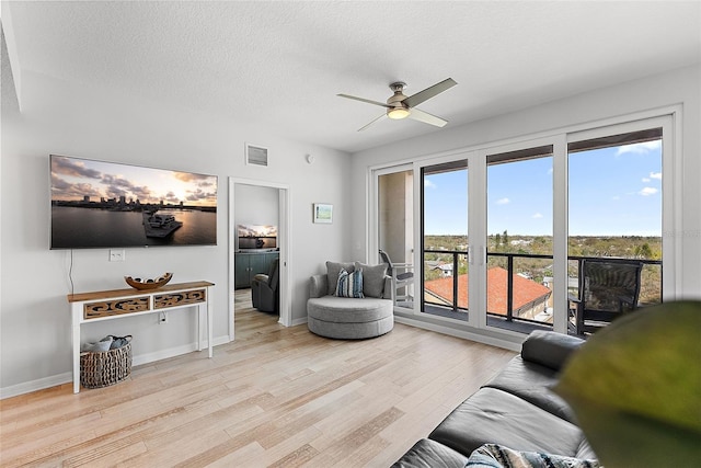 226 5th Ave N Unit 901, Saint Petersburg, FL 33701 - living area featuring visible vents, ceiling fan, a textured ceiling, light wood-type flooring, and baseboards