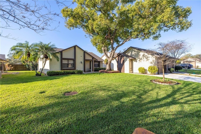 view of front of house with stucco siding, a front lawn, and fence