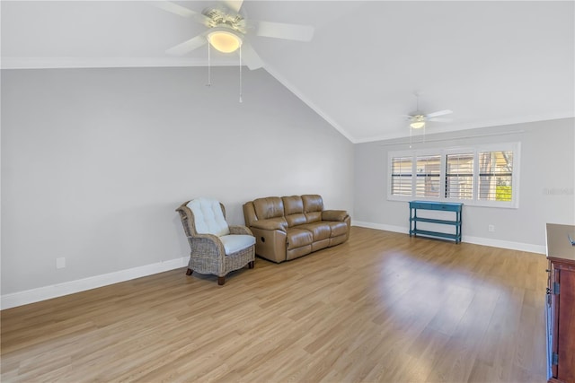 sitting room with a ceiling fan, baseboards, light wood finished floors, lofted ceiling, and crown molding