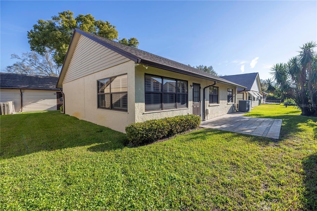 back of house featuring a patio, a yard, and stucco siding