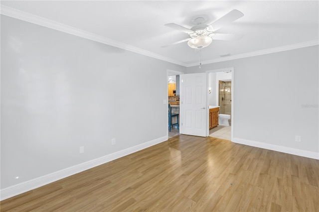 unfurnished bedroom featuring baseboards, light wood-style floors, ensuite bathroom, and crown molding