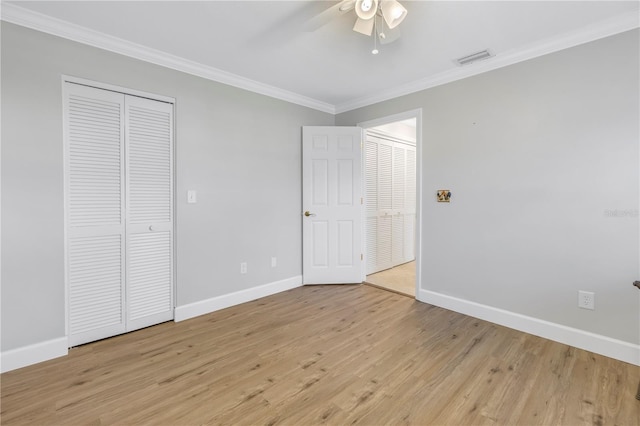 unfurnished bedroom featuring visible vents, light wood-style flooring, crown molding, and baseboards