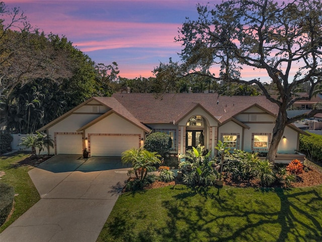 view of front of home featuring a front yard, concrete driveway, an attached garage, and stucco siding