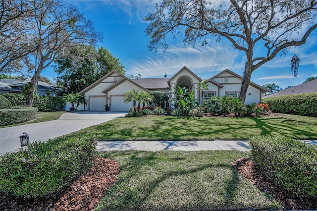 tudor-style house featuring a front lawn, concrete driveway, and an attached garage