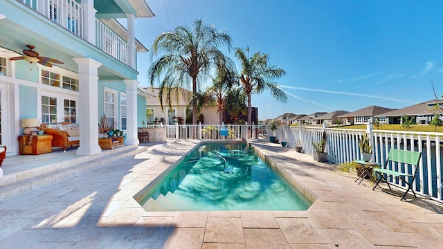 view of swimming pool featuring a ceiling fan, a patio area, a residential view, and a fenced in pool