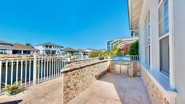 view of patio with a residential view, an outdoor kitchen, and area for grilling