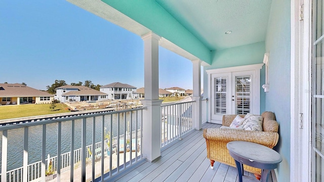 balcony featuring a residential view and a water view