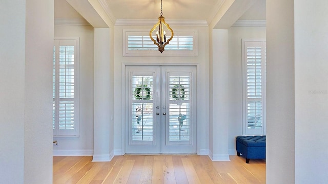 foyer entrance with baseboards, ornamental molding, wood finished floors, and french doors