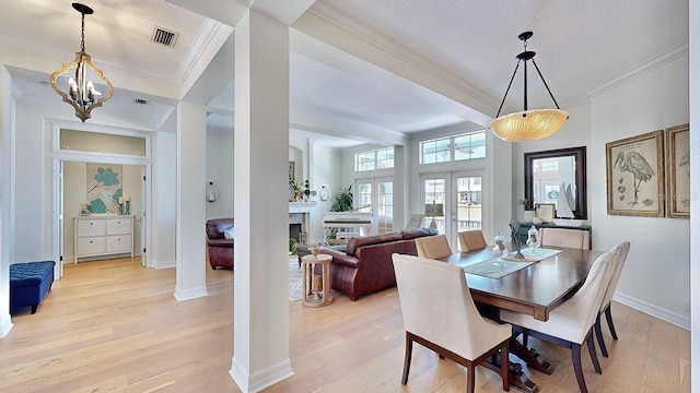 dining room featuring light wood finished floors, visible vents, crown molding, and french doors