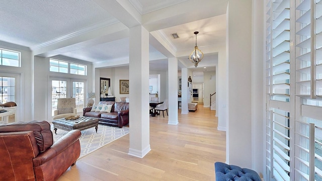 entrance foyer with visible vents, stairs, french doors, light wood-type flooring, and crown molding