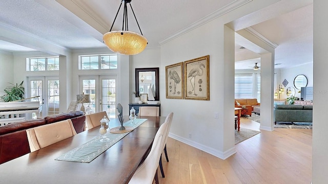 dining area with ornamental molding, light wood-type flooring, french doors, and baseboards