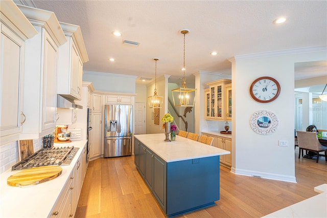 kitchen featuring visible vents, light wood-style floors, appliances with stainless steel finishes, light countertops, and under cabinet range hood