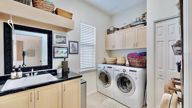 laundry room with light tile patterned flooring, a sink, baseboards, independent washer and dryer, and cabinet space