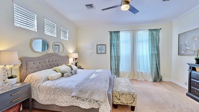 bedroom featuring baseboards, visible vents, crown molding, and wood finished floors