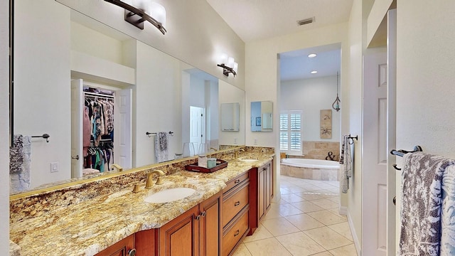 bathroom with tile patterned flooring, a sink, visible vents, a bath, and double vanity